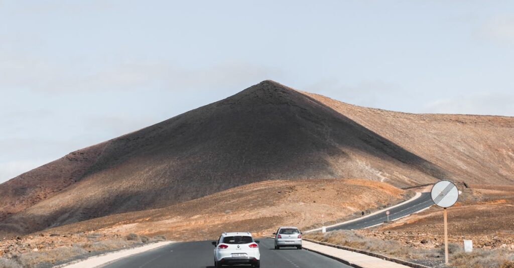 A serene drive through Lanzarote's arid landscape, featuring a winding mountain road under a clear sky.