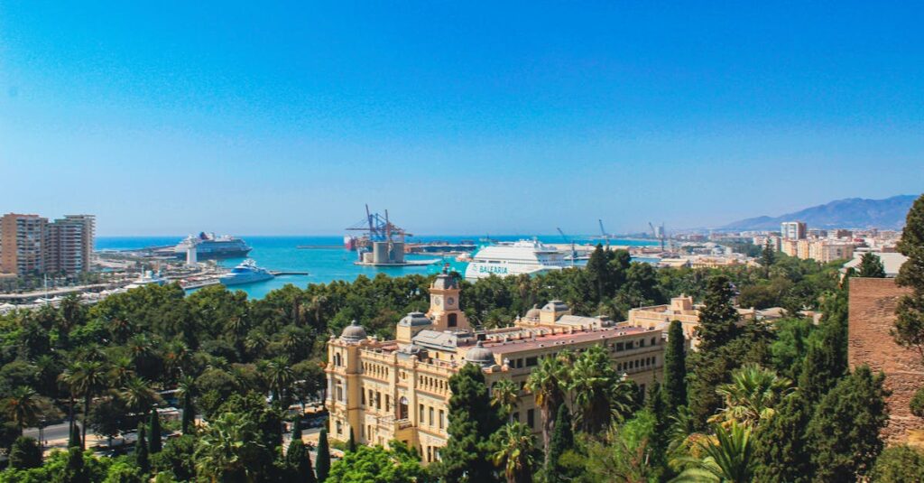 Breathtaking aerial view of Málaga, Spain featuring the bustling port and lush greenery.